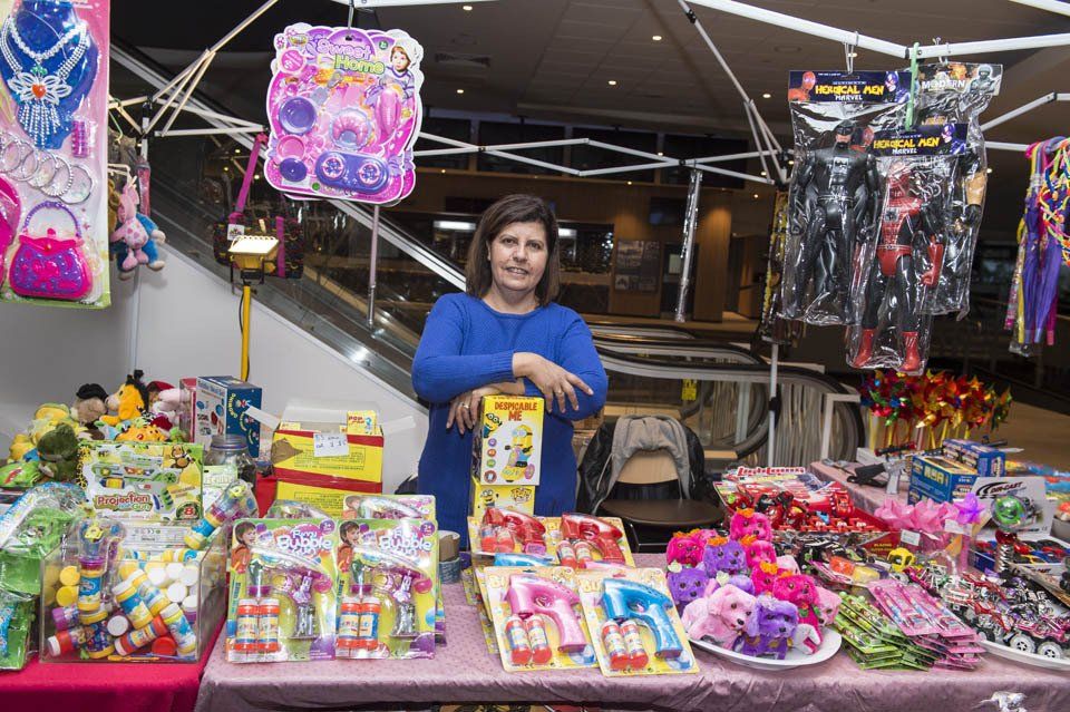 A woman is standing in front of a table full of toys.