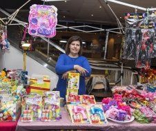 A woman is standing in front of a table full of toys.