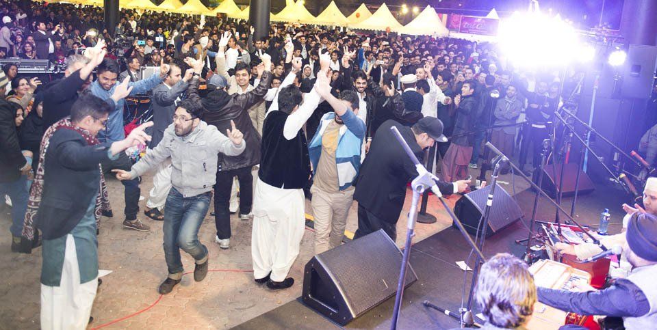 A group of people are dancing in front of a stage.