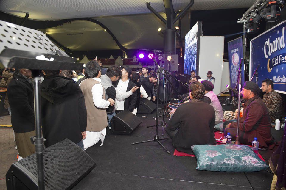 A group of people are sitting on the floor in front of a stage.