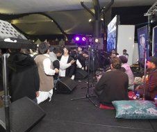 A group of people are sitting on the floor in front of a stage.