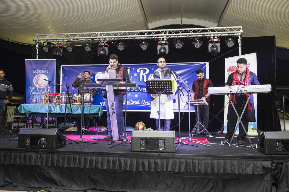 A group of men are standing on a stage playing keyboards