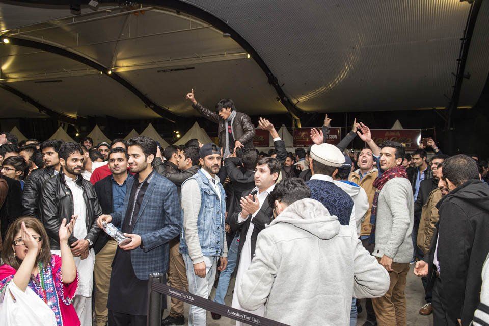 A large group of people are standing in a room.