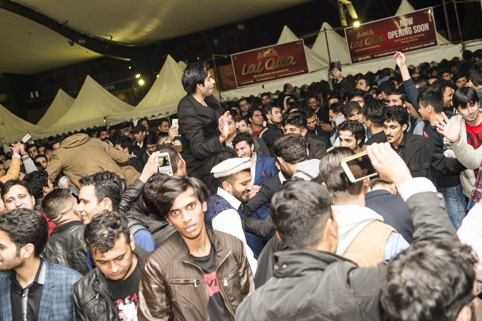 A crowd of people are gathered in a stadium watching a concert.