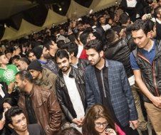 A large group of people are standing in a crowd at a party.