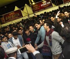 A man is taking a picture of a crowd of people at a festival.