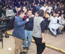 A group of men are dancing in front of a crowd of people.