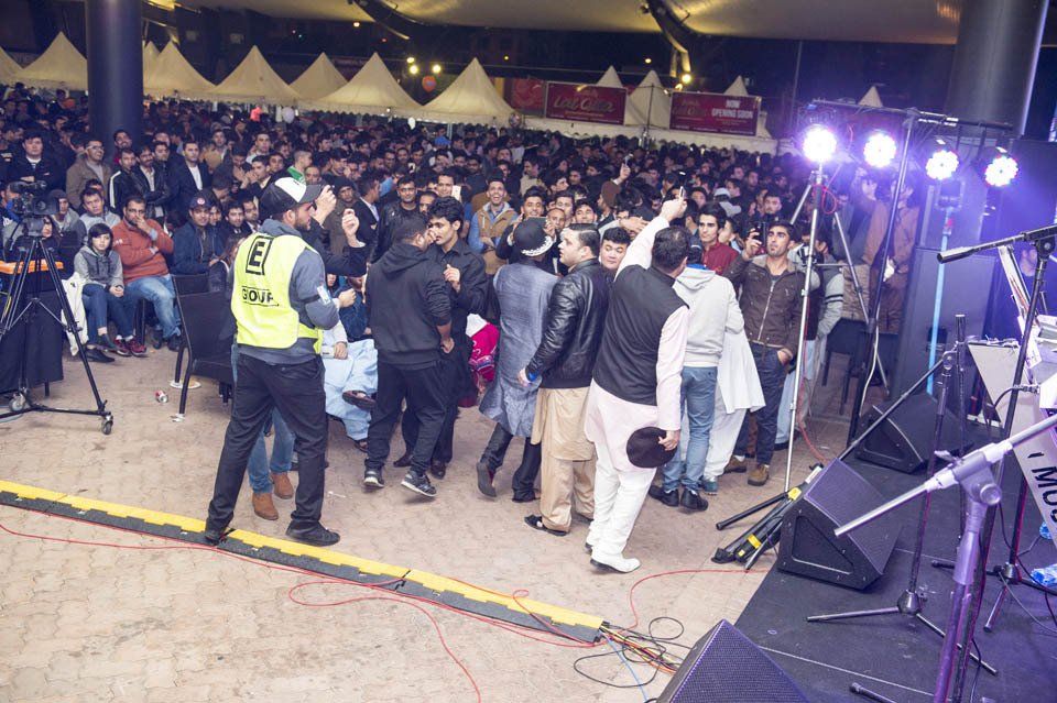 A crowd of people are gathered on a stage at a concert.