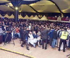 A large crowd of people are gathered in a large room.