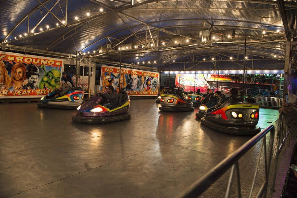 A group of people are riding bumper cars at an amusement park.