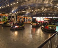 A group of people are riding bumper cars at a carnival.