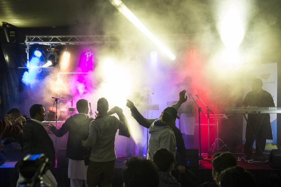 A group of people are dancing on a stage at a concert.