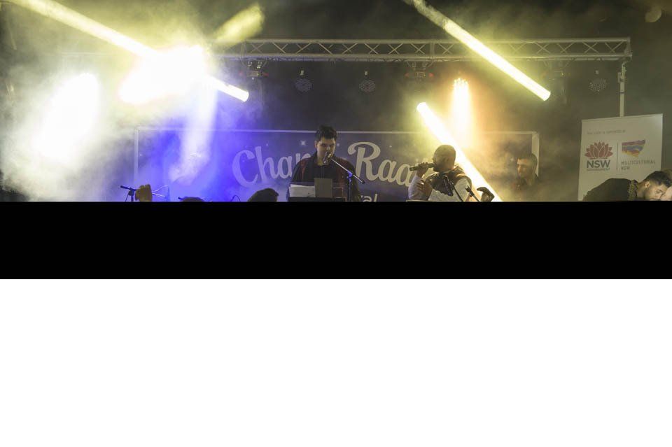 A group of people are standing on a stage in front of a sign that says choir race.