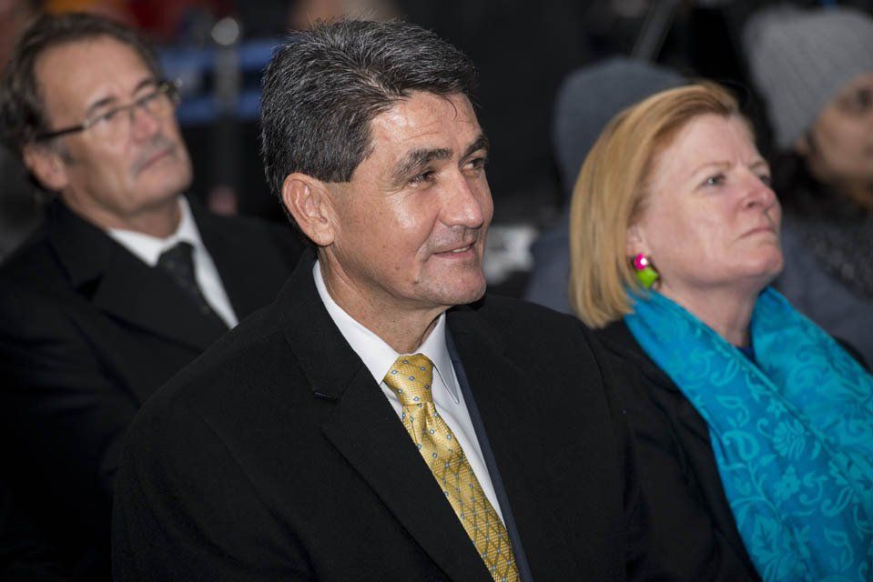 A man in a suit and tie is sitting next to a woman in a blue scarf.