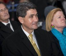 A man in a suit and tie is sitting next to a woman in a blue scarf.