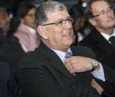 A man in a suit and tie is sitting in a crowd of people.