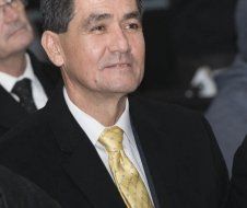 A man in a suit and tie is sitting in a row with other men.