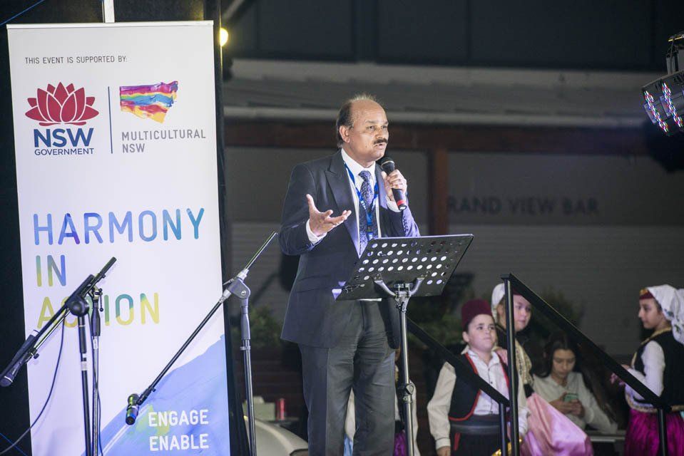A man in a suit and tie is standing in front of a microphone.