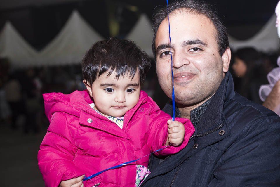 A man is holding a little girl in his arms.
