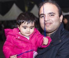 A man is holding a little girl in his arms.