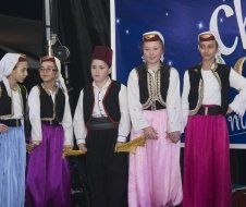 A group of children are standing in front of a sign that says clock