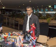A man is standing in front of a table with toys on it.