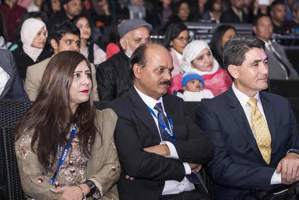 A group of people are sitting in a theatre watching a show.