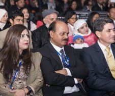 A group of people are sitting in a theater watching a presentation.