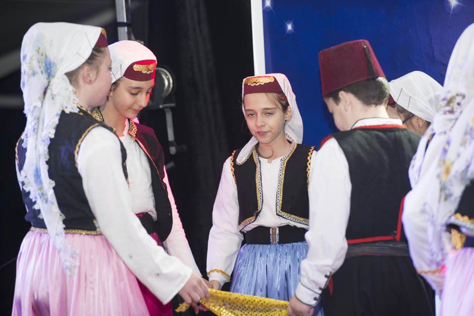 A group of people in traditional costumes are standing in a circle