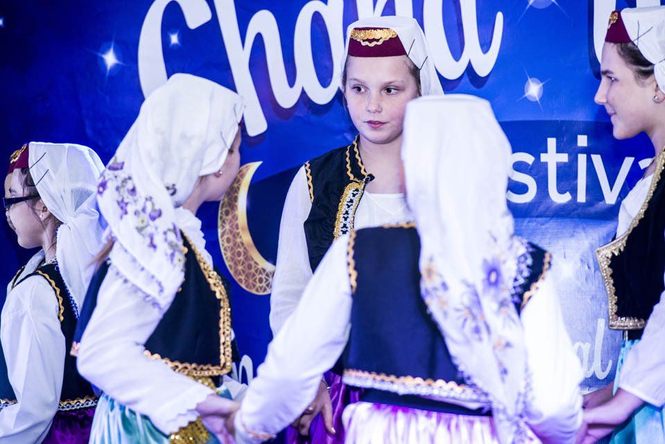 A group of young girls are dancing in front of a sign that says ' stiv ' on it.
