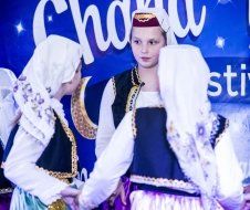 A group of children are dancing in front of a sign that says choir.