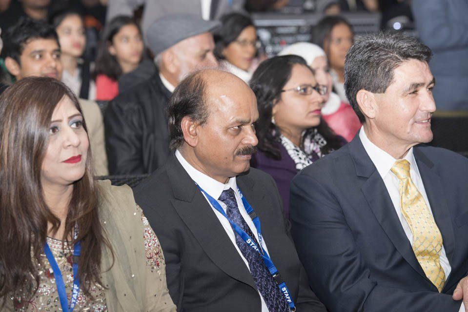 A group of people in suits and ties are sitting in a row.