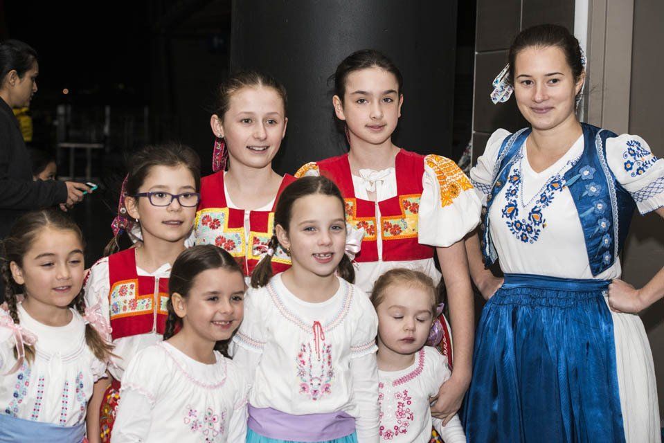 A group of young girls in traditional costume are posing for a picture.