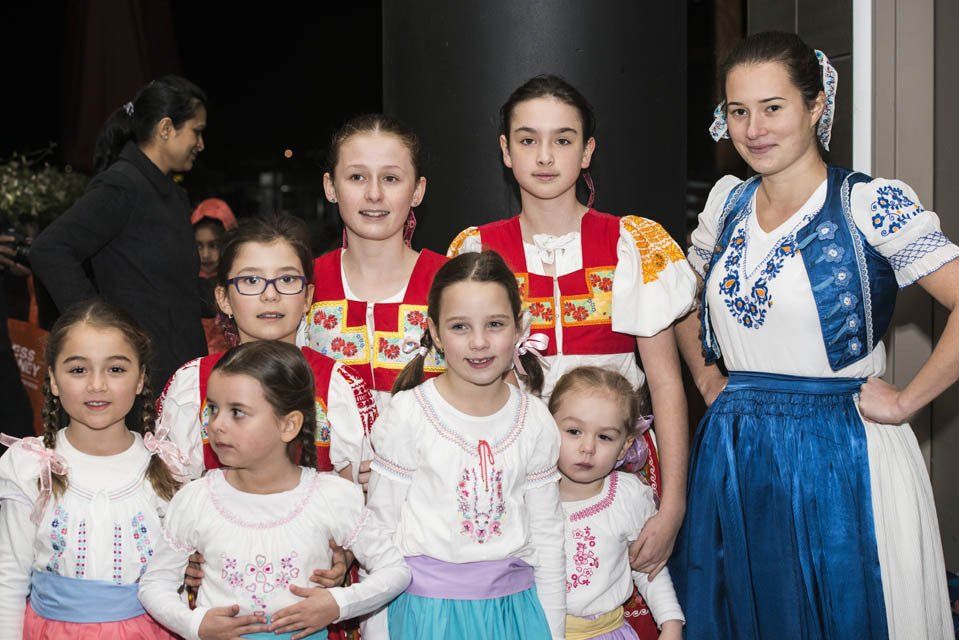 A group of young girls in traditional clothes are posing for a picture.