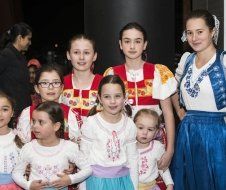 A group of young girls in traditional costumes are posing for a picture.