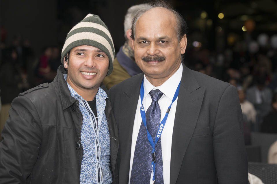 Two men posing for a picture with one wearing a beanie