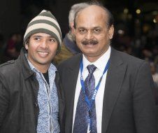 Two men in suits and ties are posing for a picture together.