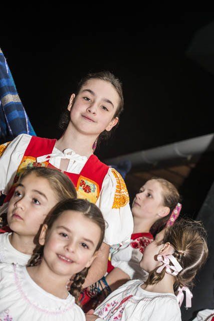 A group of young girls are sitting next to each other in a dark room.