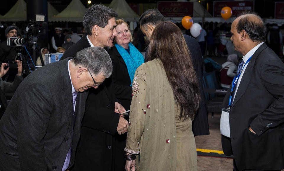 A group of people are standing around talking to each other.