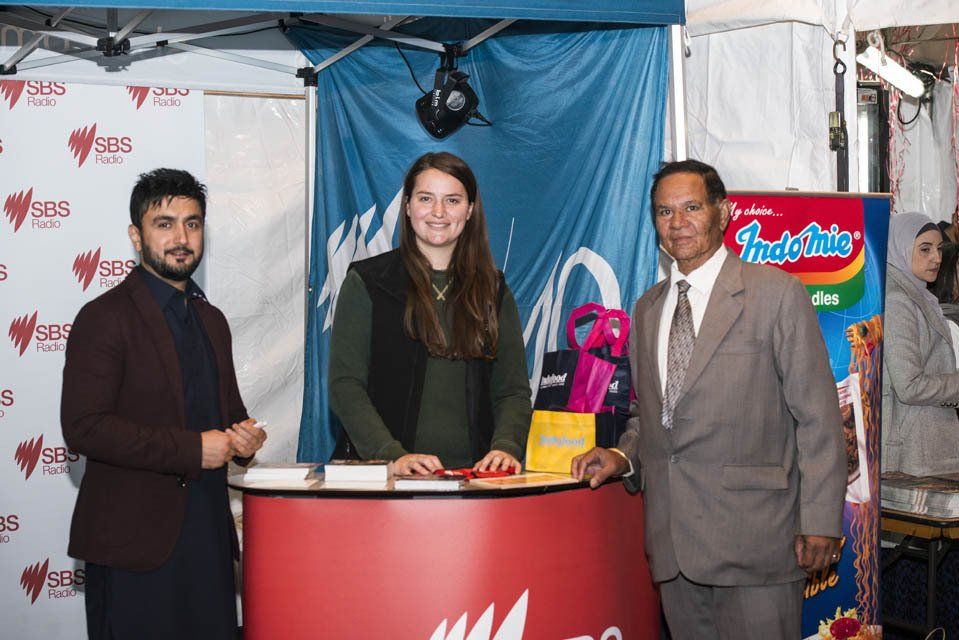A man in a suit and tie is standing next to a woman and a man in a suit.