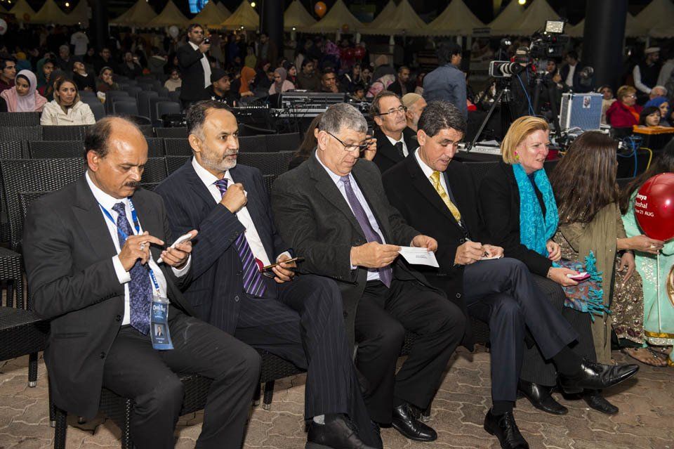 A group of people are sitting in chairs looking at their phones