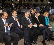 A group of people in suits and ties are sitting in a row.