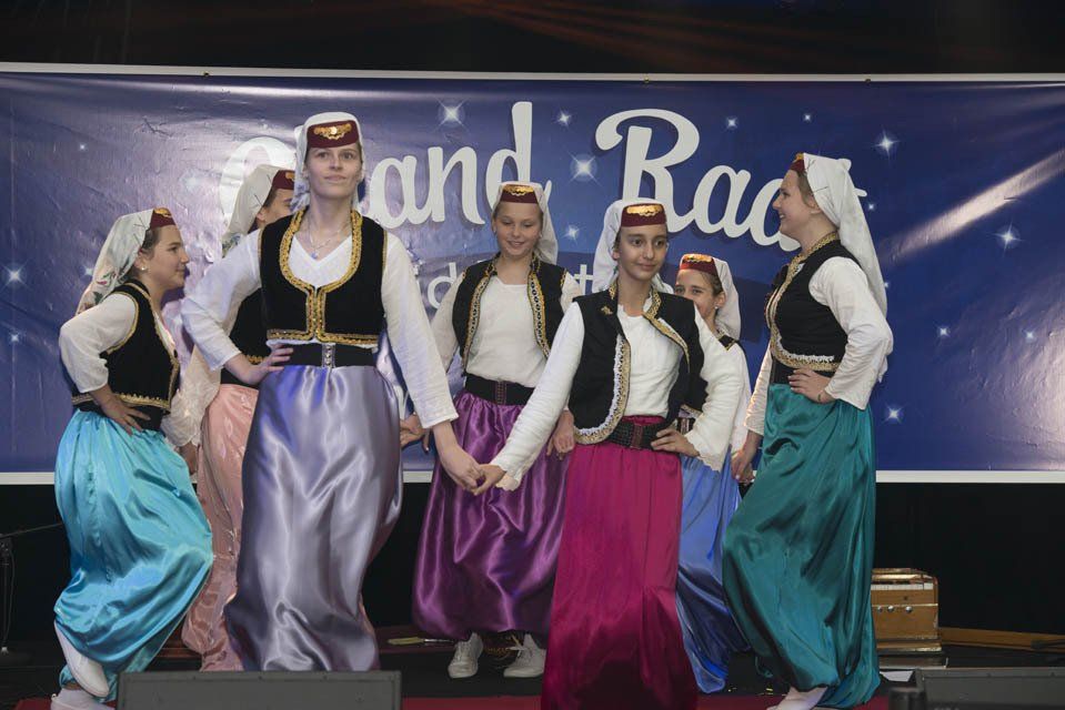 A group of women are dancing in front of a sign that says ' and race '