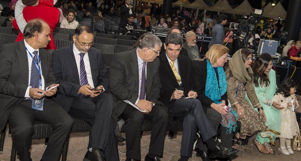 A group of people are sitting in chairs looking at their phones.