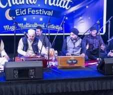 A group of men are sitting on a stage playing instruments.