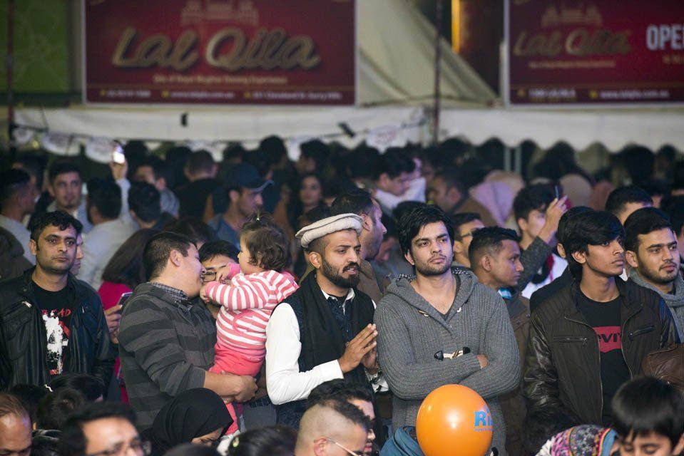 A crowd of people are sitting in a stadium watching a concert.