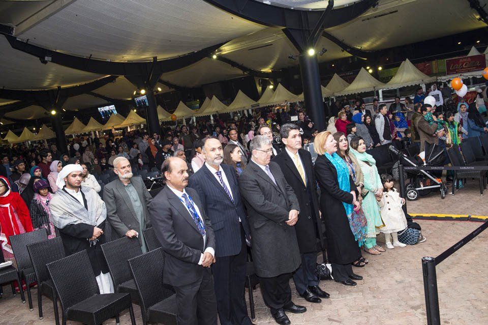 A group of people are standing in a line in front of a crowd.