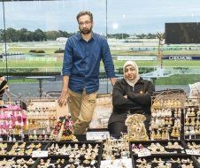 A man and a woman are standing in front of a window in a store.