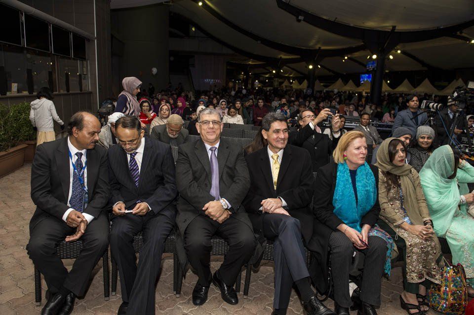 A group of people are sitting in chairs in front of a crowd.
