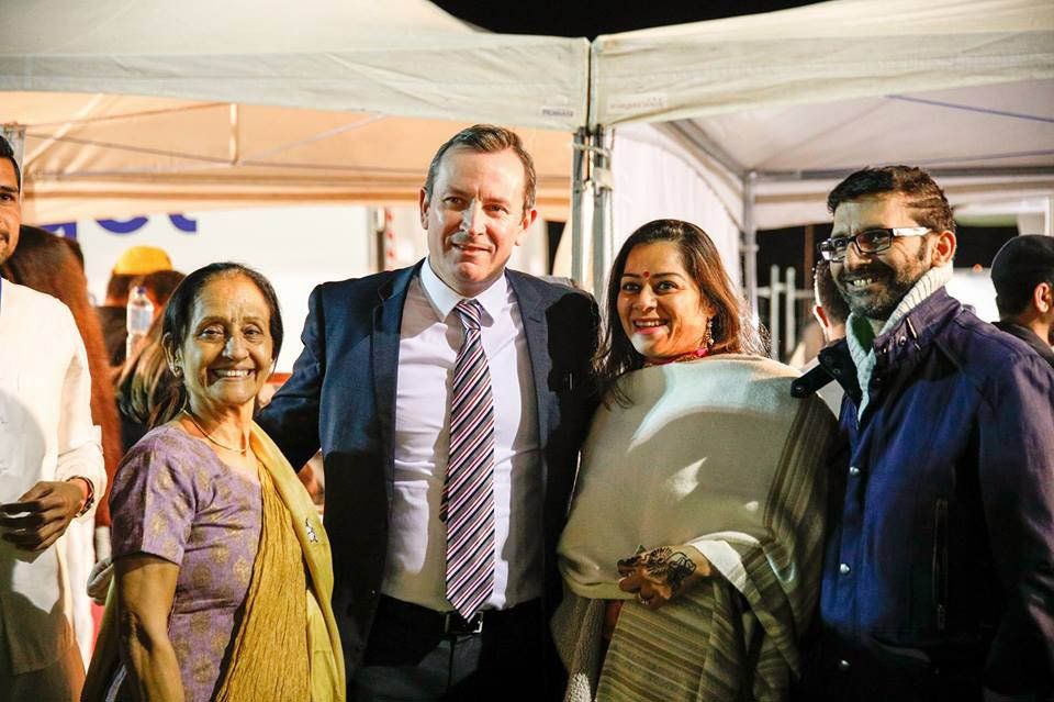 A group of people posing for a picture including a man in a suit and tie